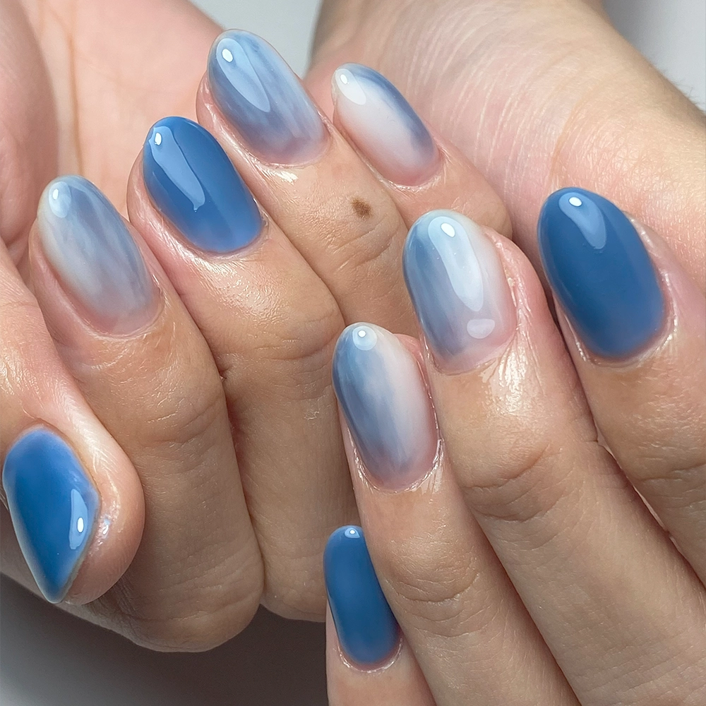 Gradasi biru memukau dalam seni nail art di She Beauty Bar Semarang, menampilkan transisi warna mulus yang mengingatkan pada lautan yang tenang, memadukan keahlian dan estetika untuk memberikan tampilan kuku yang elegan dan sofistikasi.